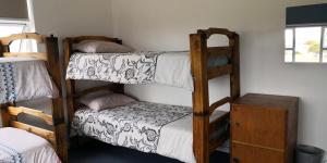 a room with two bunk beds and a small bed at Hermanus Backpackers & Budget Accommodation in Hermanus
