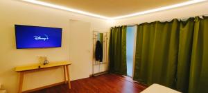 a room with green curtains and a table and a television at Jacuzzi LOVE appartement in Paris