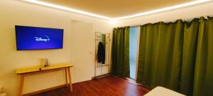 a room with green curtains and a table and a television at Jacuzzi LOVE Suite Climatisé in Paris
