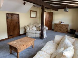 a living room with a couch and a coffee table at Brookside Barn in Lichfield