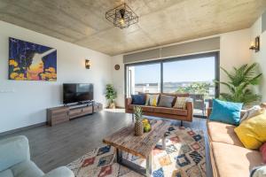 uma sala de estar com um sofá e uma televisão em As Andorinhas - Walking distance to Monte Clerigo and Amoreira beaches em Aljezur