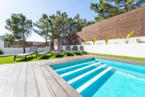 einen Pool mit Chaiselongues neben einem Pool in der Unterkunft As Andorinhas - Walking distance to Monte Clerigo and Amoreira beaches in Aljezur