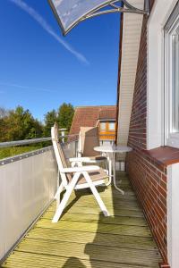 a balcony with a table and a chair on it at Ferienwohnungen Haus Saathoff in Bensersiel +57 photos