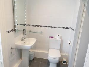 a white bathroom with a toilet and a sink at Chase Hotel in Whitehaven