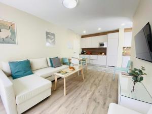 ein Wohnzimmer mit einem weißen Sofa und einem Tisch in der Unterkunft Summerlandrota Argüelles 4 in Rota