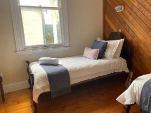 a small room with a bed with a window at Harbour Master's Cottage in Stanley