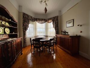 a dining room with a table and chairs and a window at Harbour Master's Cottage in Stanley