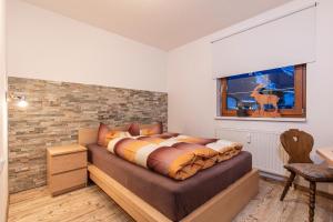 a bedroom with a bed with a brick wall at Apart Hoher Kogel in Längenfeld