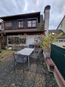 um pátio com uma mesa e cadeiras em frente a uma casa em Appartment Montfort em Feldkirch