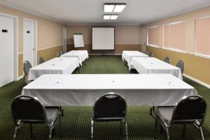 a conference room with white tables and chairs and a whiteboard at Americas Best Value Inn Vacaville in Vacaville