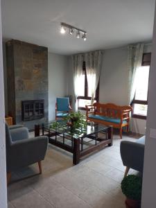 a living room with a coffee table and a fireplace at Hotel Alma Rosa in Navaluenga