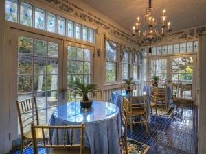 a dining room with tables and chairs and windows at Bluefield Inn, a Select Registry Propery in Bluefield