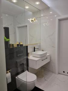 biała łazienka z toaletą i umywalką w obiekcie Apartament Wyspiański w mieście Sanok +37 zdjęć