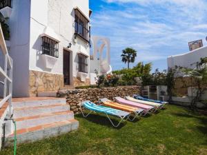 a group of lounge chairs sitting next to a building at Villa Azahara in Nerja
