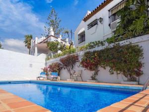 a swimming pool in front of a house at Villa Azahara in Nerja