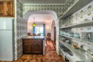 a kitchen with a refrigerator and shelves with dishes at Villa Azahara in Nerja