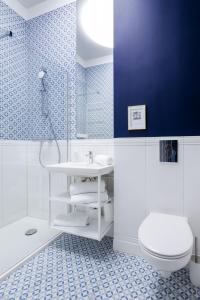 a bathroom with a white sink and a toilet at Philharmonic Apartment in Szczecin