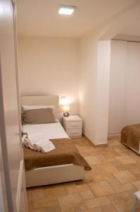 a white bedroom with a bed and a night stand at Cann'e Sisa Luxury Villa Perla Marina A in Torre delle Stelle