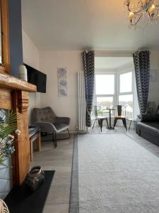 a living room with a couch and a table at Newly renovated 1st floor apartment with mountain views in Tywyn