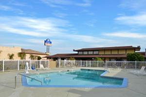 a large swimming pool with chairs and a building at Americas Best Value Inn Vacaville in Vacaville
