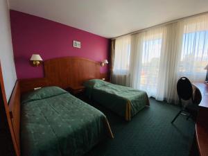 een hotelkamer met twee bedden en een raam bij Hotel Pietrak in Trzemeszno