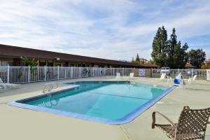a large swimming pool with a chair and a table at Americas Best Value Inn Vacaville in Vacaville +7 photos