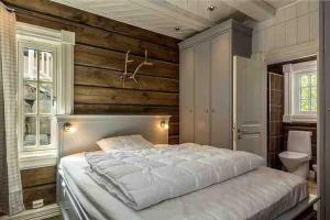 a bedroom with a large bed and wooden walls at Stor og eksklusiv tømmerhytte Hemsedal in Grøndalen