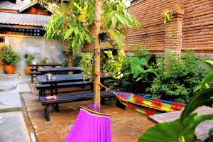 una hamaca en un jardín con bancos y árboles en Supermoon Cozy Hostel, en Pai