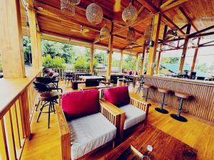 a restaurant with a bar with benches and tables at Supermoon Cozy Hostel in Pai