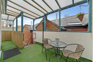 a patio with a table and chairs on a balcony at Stuning Central Oxford 2 Bedroom Flats Free WiFi in Oxford