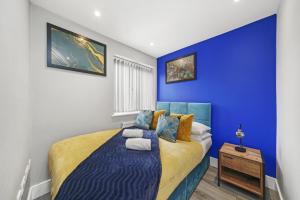 a blue bedroom with a bed with towels on it at Stuning Central Oxford 2 Bedroom Flats Free WiFi in Oxford