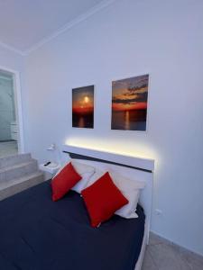 a bedroom with a bed with red and white pillows at Pôr do Sol in Funchal
