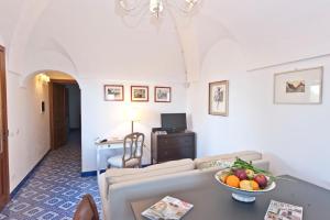 un soggiorno con divano e un cesto di frutta sul tavolo di Resort Acropoli a Pantelleria