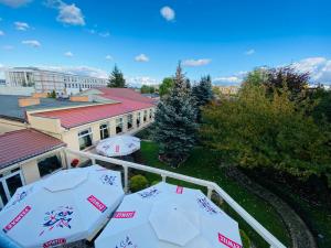 een uitzicht op een gebouw met twee parasols bij Hotel Pietrak in Trzemeszno