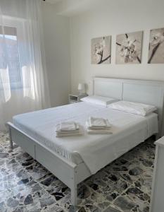 een witte slaapkamer met een bed met twee handdoeken erop bij Casa Gelindo - large and fine apartment with two bathrooms in Sestri Levante