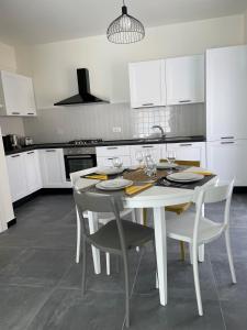 een witte keuken met een witte tafel en stoelen bij Casa Gelindo - large and fine apartment with two bathrooms in Sestri Levante