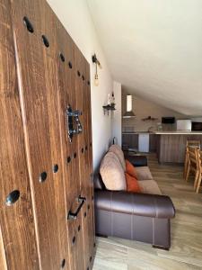 een kamer met houten deuren in een kamer met een bank bij Casa rural huertas largas in Casarabonela