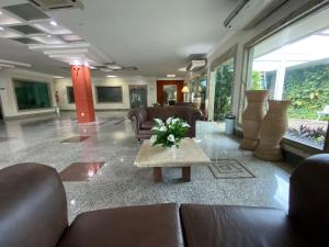 um lobby com sofás e uma mesa com flores em AQUARIUS HOTEL em Porto Velho