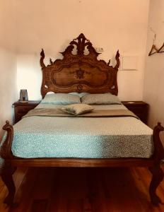 a bed with a wooden headboard in a bedroom at Beautiful small House in Algarve Portugal in Mexilhoeira Grande