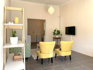 a living room with two yellow chairs and a mirror at Hermanus 2 bed (Incl King bed) - Walk to the sea! in Hermanus