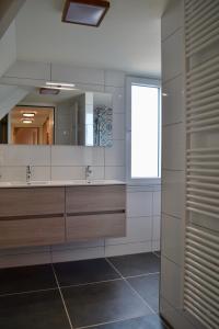 un bagno con due lavandini e un grande specchio di Luxe vakantievilla Zoutelande a Zoutelande