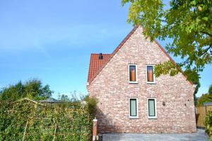 a brick house with a red roof at Luxe vakantievilla Zoutelande in Zoutelande