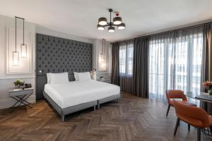 a bedroom with a white bed and a table and chairs at Wish More Hotel Şişli in Istanbul