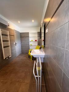 a bathroom with a sink and yellow chairs at Maison Purrussoni in Levie