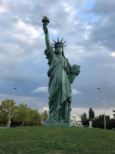 una estatua de la estatua de la libertad con su mano en el aire en Le Green Cocoon au dessus du vignoble Alsacien en Turckheim