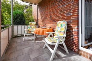 two chairs and a table on a patio at Ferienwohnungen Haus Saathoff in Bensersiel
