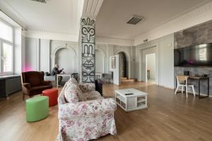 a living room with two chairs and a man sitting at a table at Casa De Wawa in Warsaw