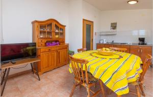a kitchen with a table with a yellow and white striped table cloth at Apartmen Valkanela Vi in Vrsar