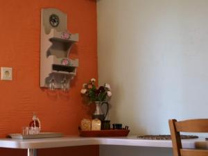 uma mesa com um vaso de flores na parede em Η Φωλιτσα em Karpenision