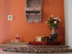 a shelf with a vase of flowers on a wall at Η Φωλιτσα in Karpenisi